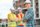 Confidence. Confident man in safety helmet with folded hands smiling at camera and workers standing behind at construction site